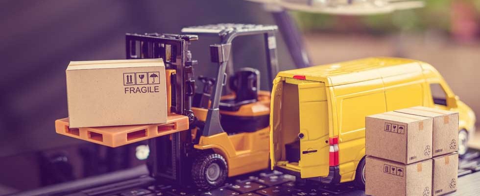 toy forklift and van on keyboard to illustrate supply chain