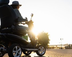 Person driving a powerchair at sunset