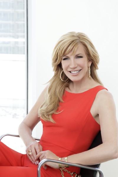 Leeza Gibbons seated in chair in red dress