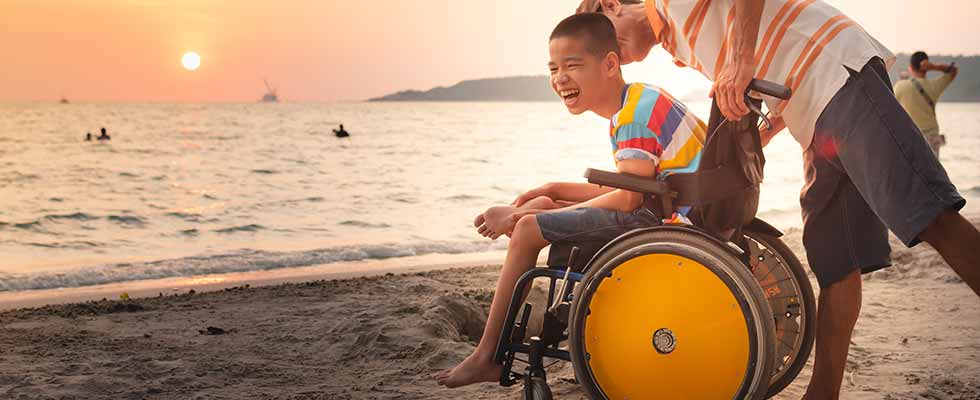 child on beach in wheelchair