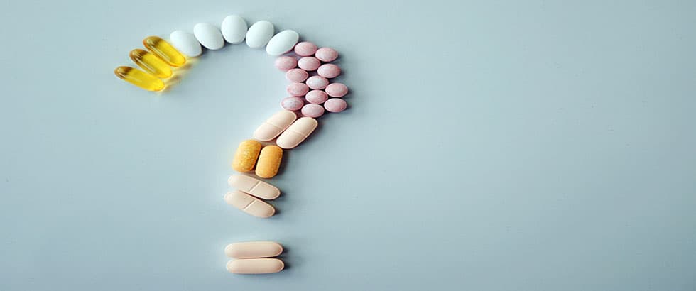 various pills in the shape of a question mark