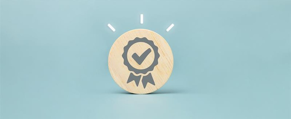 A wooden circle with a ribbon containing a checkmark symbol on a blue background. The circle has three lines for emphasis around it. 