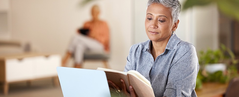 An image of a black woman with short hair reading a book