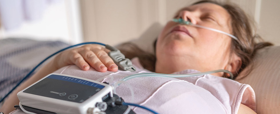 A woman laying down while wearing sleep study equipment.
