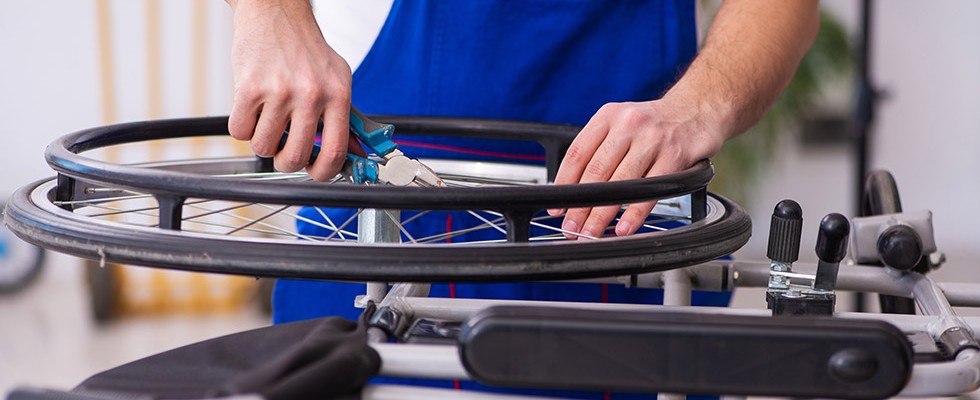 An image of someone repairing the wheel of a wheelchair