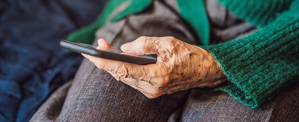An older woman's hand with a smart phone