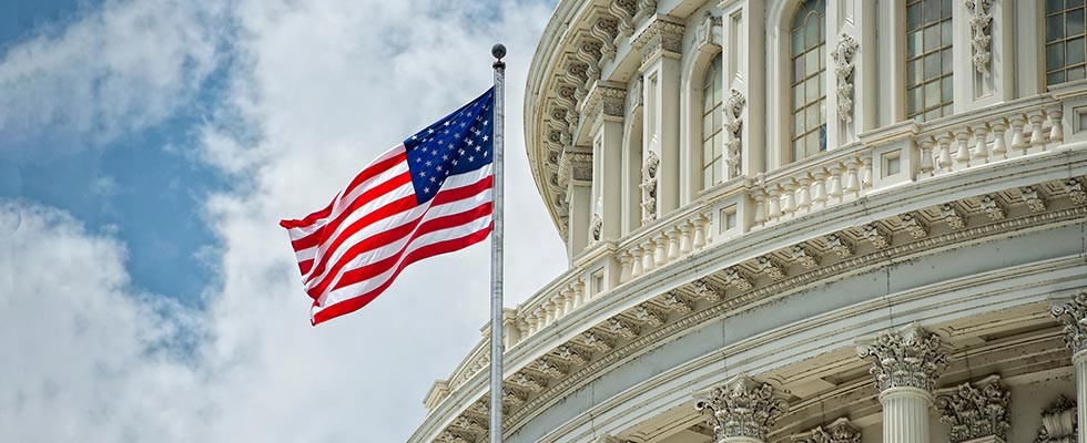 An image of Capitol Hill with the American flag in front of it. 