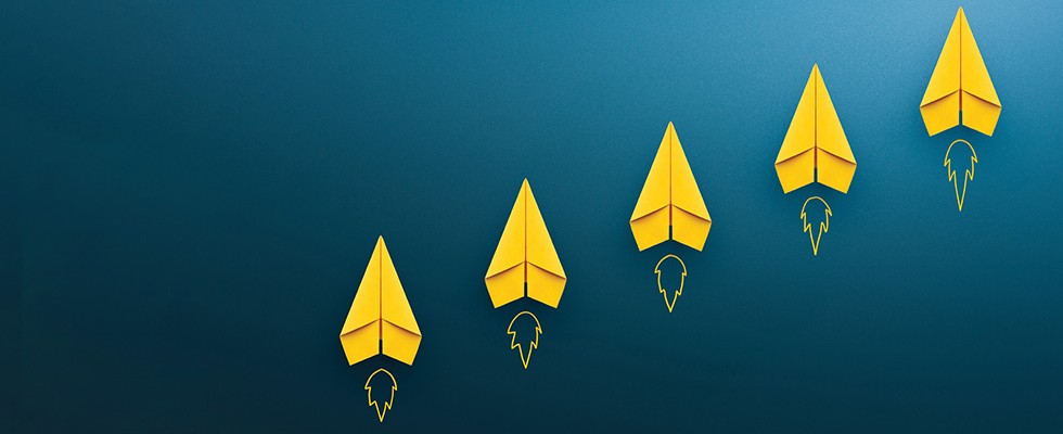 five yellow paper airplanes on a blue background. under each paper airplane their our illustrations of fire as if they are "taking off"