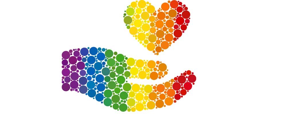 hand in pride colors holding a heart