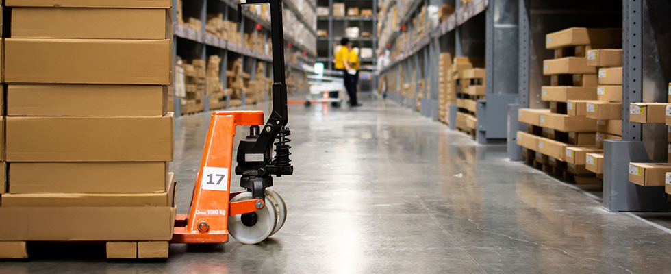 The floor of a warehouse. Box panels are stacked on a dolly.