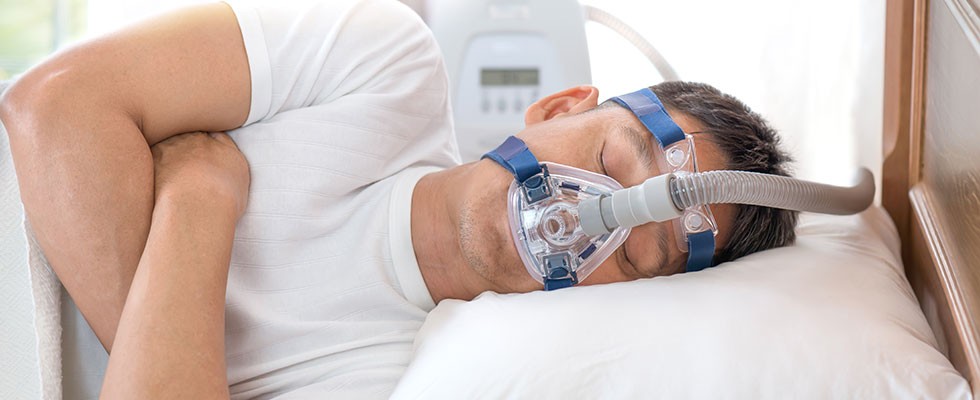 man sleeping with CPAP mask on face