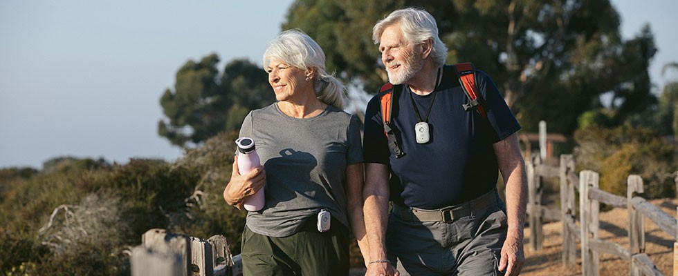 couple hiking with pers devices