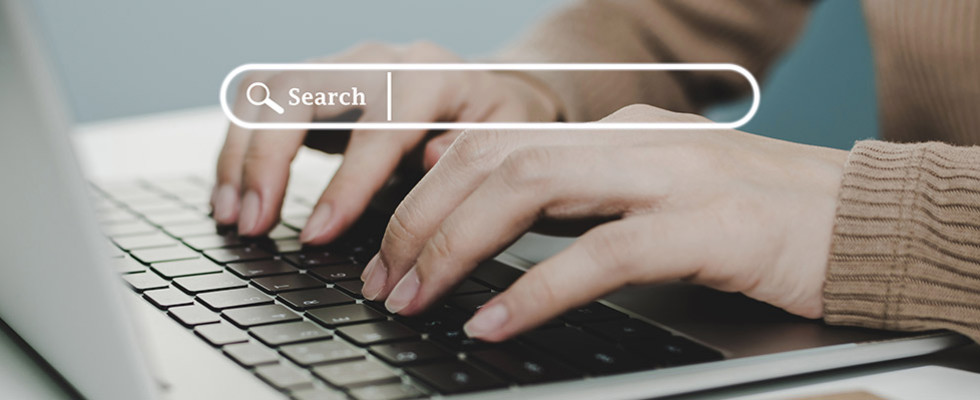 Hands typing on a keyboard with a search bar hovering above