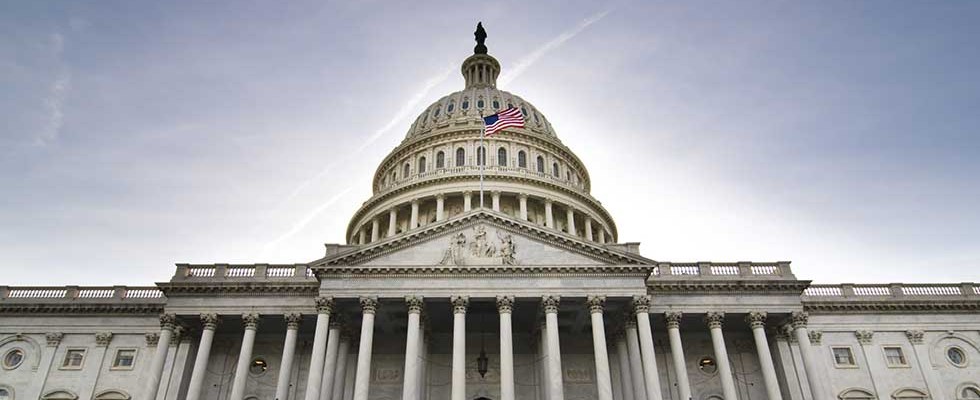 US Capitol Building and Flag against a blue sky