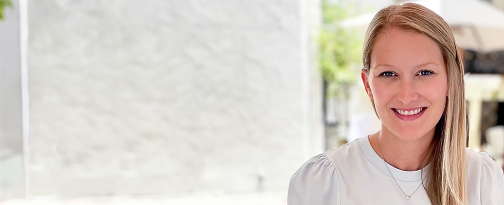 Amy Marchant sits and smiles in front of a white background.