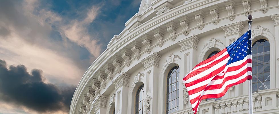 US Capitol Building and Flag against a blue sky