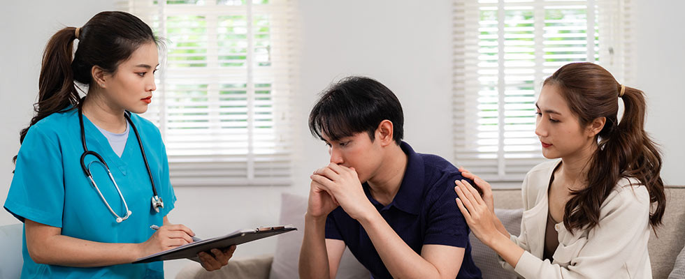 A caregiver talking with a young couple