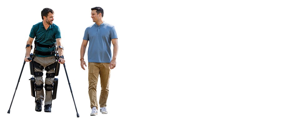 Two men stand next to each other, one of them with leg braces and crutches.