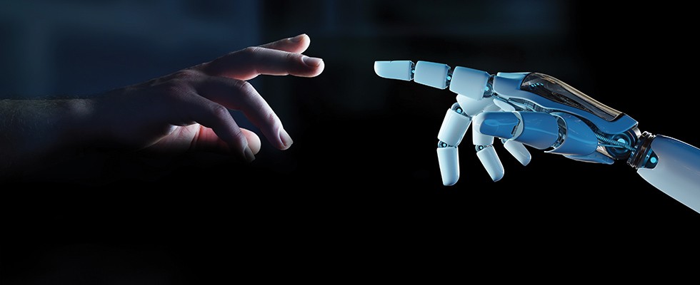 A human hand reaching out to a robot hand on a dark background