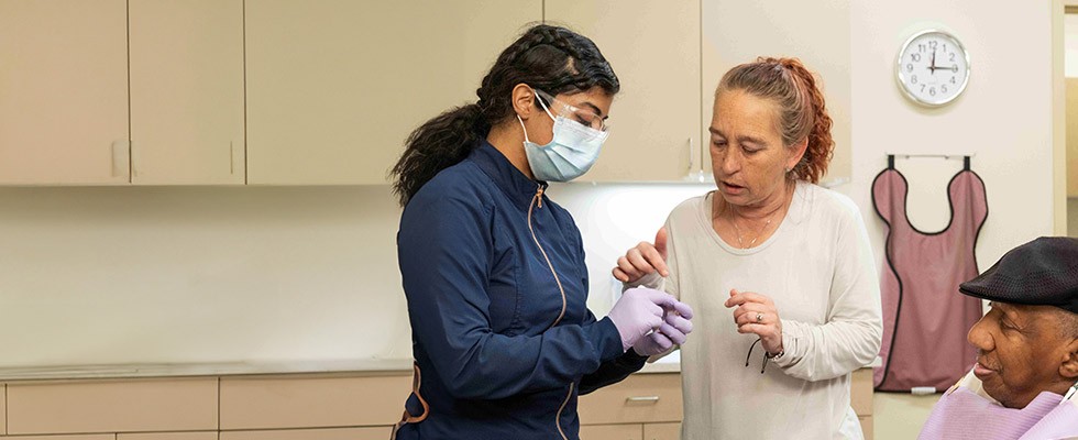 A dentist is working with a patient and his caregiver