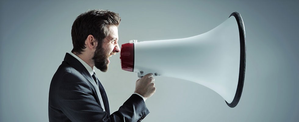 man yelling into megaphone