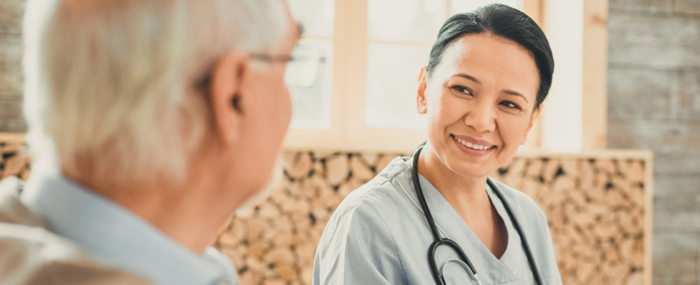 A physician sitting with an elderly patient.