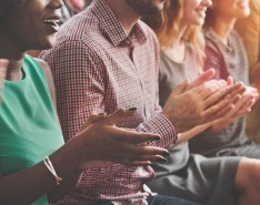 Image of people sitting down, clapping