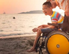 child on beach in wheelchair