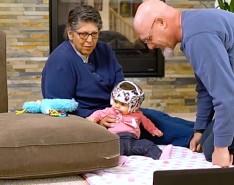 baby in a helmet working with man and woman .