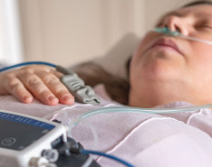 A woman laying down while wearing sleep study equipment.