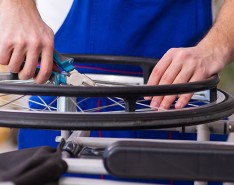 An image of someone repairing the wheel of a wheelchair