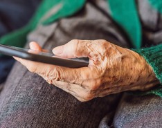An older woman's hand with a smart phone