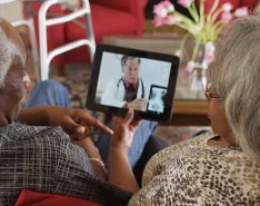 elderly Black couple chats with doctor on iPad