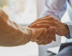 Two people holding hands in a hospice setting