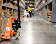 The floor of a warehouse. Box panels are stacked on a dolly.