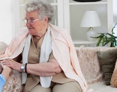 older white woman holding hands with white female nurse