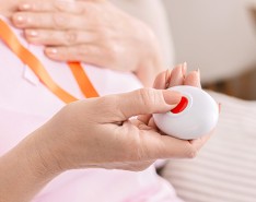 woman holding a personal emergency response system button