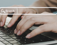 Hands typing on a keyboard with a search bar hovering above
