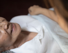 An elderly woman looking up at her caregiver