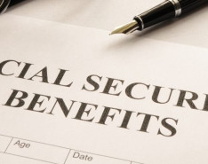 A Social Security Benefits form with a pen and glasses on top of it