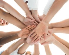 health care professionals putting their hands in to a pile for a celebration cheer