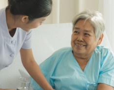  female caregiver helps a woman at home