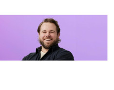 Jordan Faeth smiling in front of a purple background