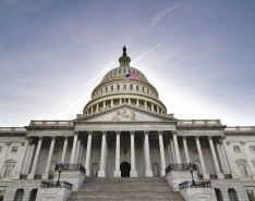 US Capitol Building and Flag against a blue sky