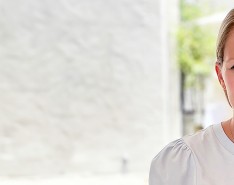 Amy Marchant sits and smiles in front of a white background.