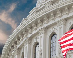 US Capitol Building and Flag against a blue sky