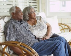 older Black couple relaxing on a porch