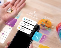 A person holding an iPhone with several screen widgets off to the side as well as a medicine organizer