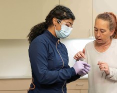 A dentist is working with a patient and his caregiver