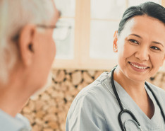 A physician sitting with an elderly patient.